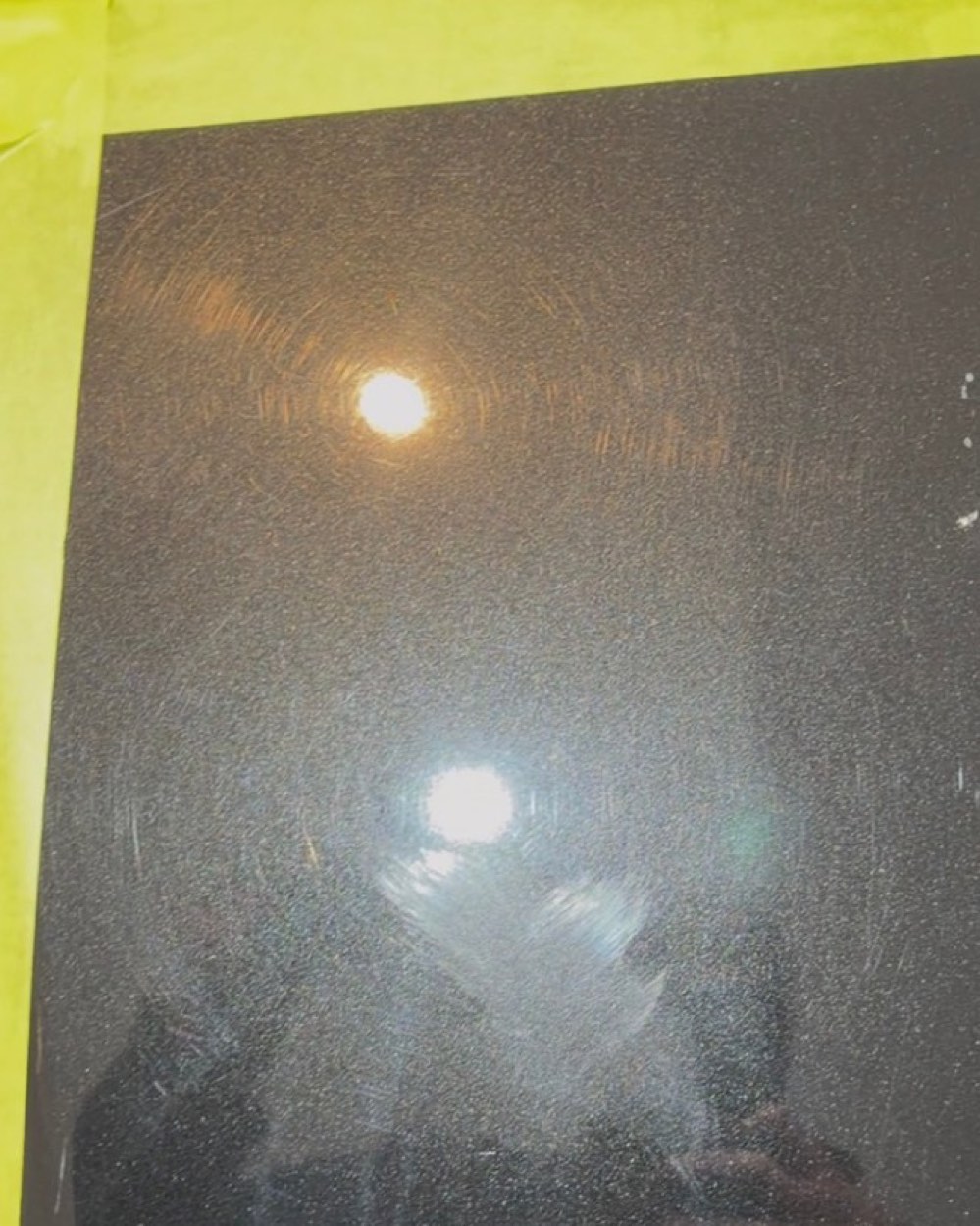 Taped test section on a black Holden Commodore SSV bonnet, swirled paint then fully corrected — before