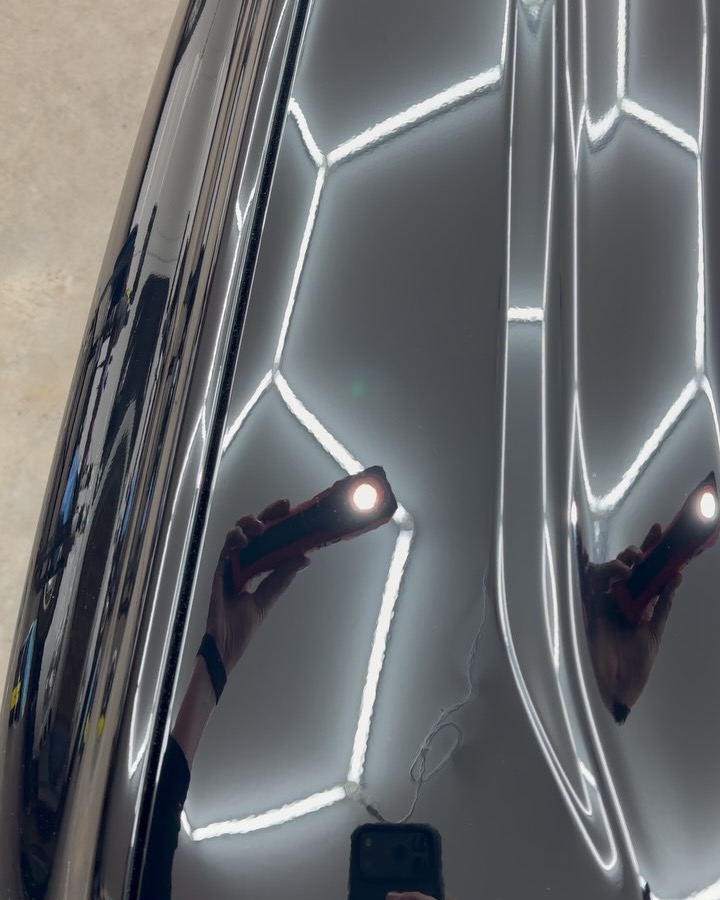 Black Ford Everest bonnet under inspection light, heavy swirl marks then a mirror finish after a three stage paint correction — after