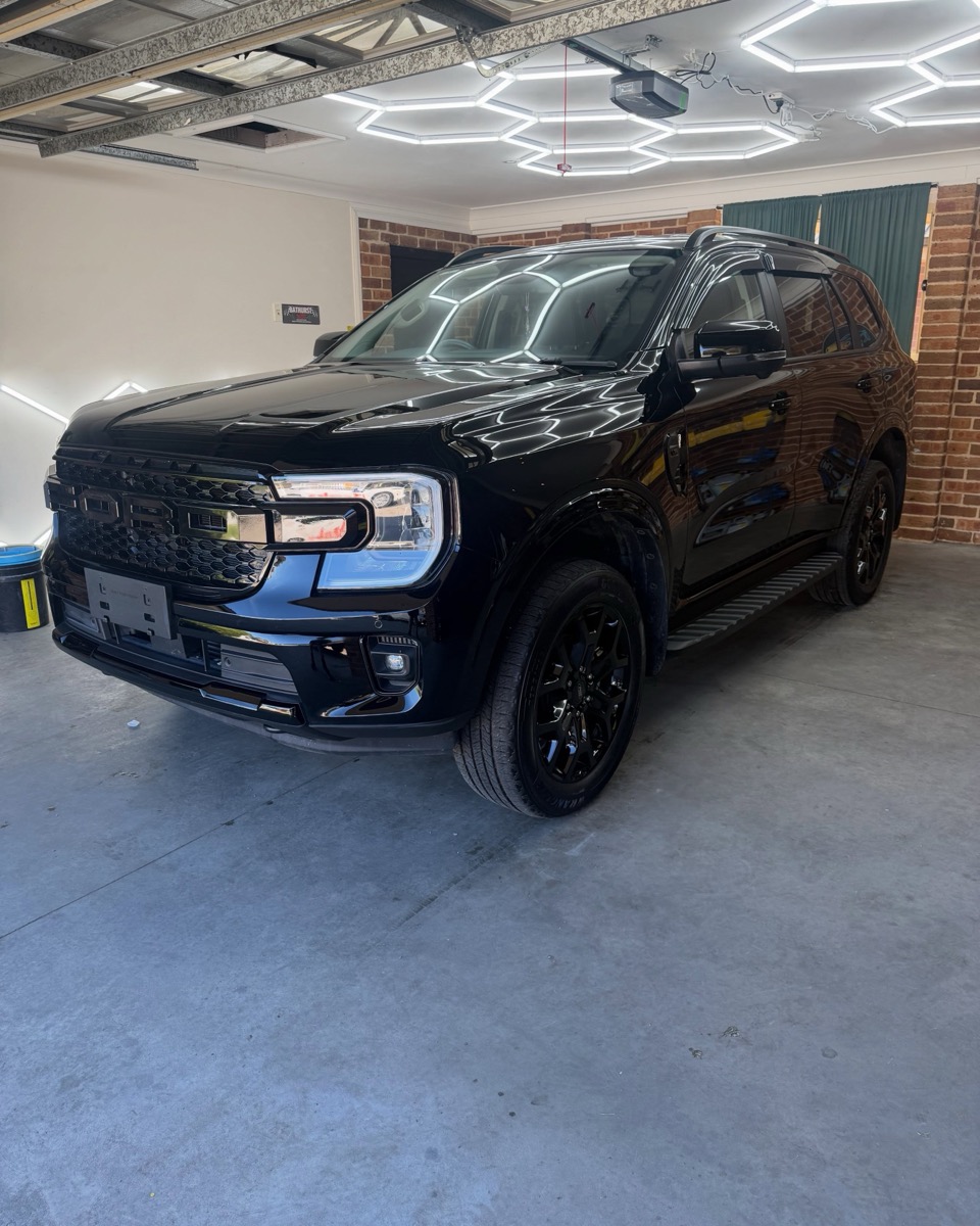 Black Ford Everest under inspection lighting after a three stage paint correction